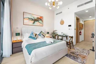 a bedroom with a large bed and a table at Stylish City Studio with Burj Khalifa View in Dubai
