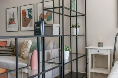 a black book shelf in a living room with a couch at GuestReady Holiday Homes - Industrial Chic in Dubai