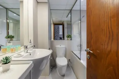 a white bathroom with a toilet and a sink at GuestReady Holiday Homes - Industrial Chic in Dubai