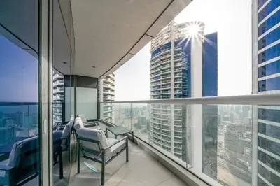 an apartment balcony with chairs and a view of a skyscraper at High Floor Burj Khalifa View Luxurious 1BR in Dubai
