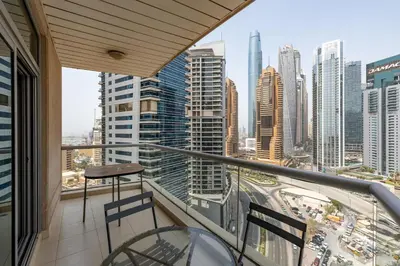 a balcony with two chairs and a view of a city at Blakely Tower, Park Island, Dubai Marina - Mint Stay in Dubai