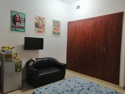 a living room with a black leather chair and a cabinet at Al Barsha Hostel for Girls in Dubai