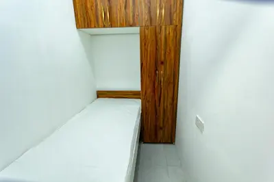 a small room with a bed and a wooden door at Al Barsha Hostel for Girls in Dubai