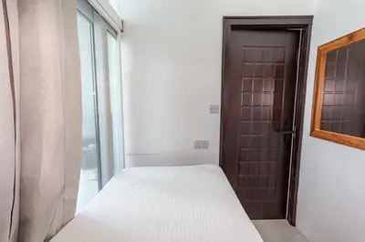a small bedroom with a bed and a door at Al Barsha Hostel for Girls in Dubai