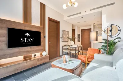 a living room with a tv on a wall at STAY BY LATINEM Luxury 1BR Holiday Home CC 0813 Near Downtown in Dubai