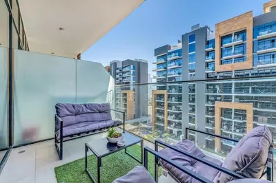 a balcony with two chairs and a table at Studio in Azizi with Free Pool and Gym Access in Dubai