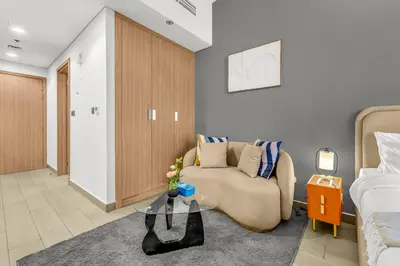 a living room with a couch and a bed at Studio in Azizi with Free Pool and Gym Access in Dubai