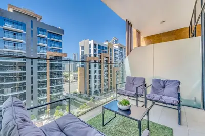 a living room with a couch and chairs on a balcony at Studio in Azizi with Free Pool and Gym Access in Dubai