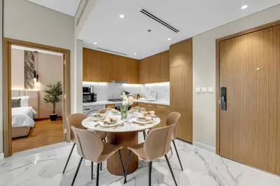 a kitchen and dining room with a table and chairs at 2BR Guest Favorite Elegant Apartment at Riviera 67 in Dubai