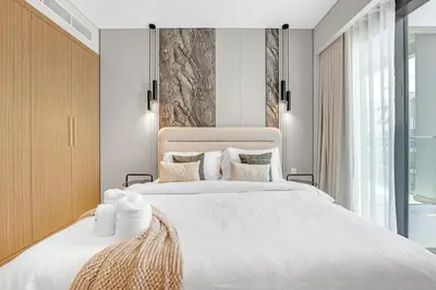 a bedroom with a large white bed and a window at 2BR Guest Favorite Elegant Apartment at Riviera 67 in Dubai