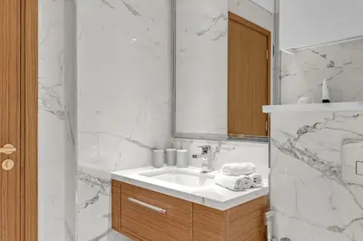 a white bathroom with a sink and a mirror at 2BR Guest Favorite Elegant Apartment at Riviera 67 in Dubai