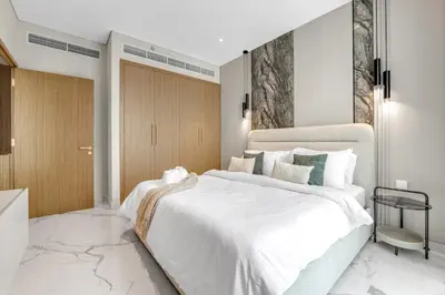 a bedroom with a large bed with white sheets at 2BR Guest Favorite Elegant Apartment at Riviera 67 in Dubai