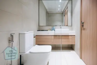 a bathroom with a toilet and a sink and a mirror at Exclusive 2BR With City View Pool & Gym Access in Dubai