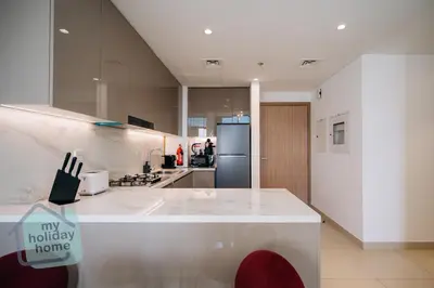 a kitchen with a white counter and a refrigerator at Exclusive 2BR With City View Pool & Gym Access in Dubai