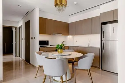 a kitchen with a table and chairs and a refrigerator at Burj Khalifa View Apartment in Dubai