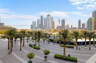 a park with palm trees in front of a city at Burj Khalifa View Apartment in Dubai