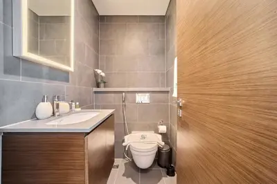 a bathroom with a toilet and a sink at FAM Living -Bright & Spacious Home in Sobha Hartland in Dubai