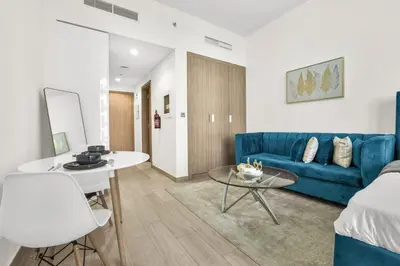 a living room with a blue couch and a table at Exclusive Downtown Dubai Studio in Dubai