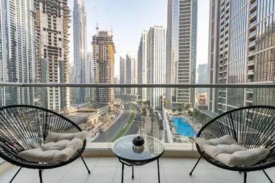a balcony with two chairs and a table and a city at The Lofts West, Downtown Dubai - Mint Stay in Dubai