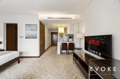 a hotel room with a bed and a kitchen at Kempinski Luxe Studio Burj Khalifa View by Evoke in Dubai