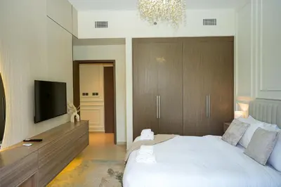 a bedroom with a bed and a flat screen tv at Iconic Burj Khalifa, Fountain Views, Luxury 2BR in Sabkhah