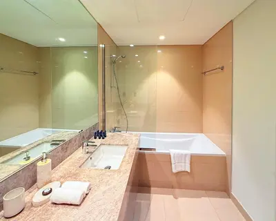 a bathroom with a tub and a sink and a shower at Iconic Burj Khalifa, Fountain Views, Luxury 2BR in Sabkhah