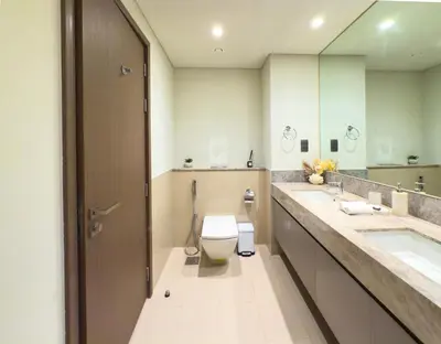 a bathroom with a toilet and two sinks and a mirror at Iconic Burj Khalifa, Fountain Views, Luxury 2BR in Sabkhah