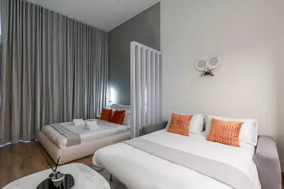 a hotel room with two beds and a fan at Luxury Apartment In JVC With Padel Gym Pool Cinema BBQ in Dubai