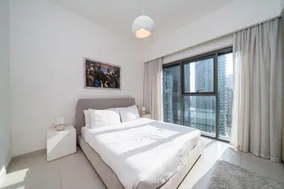a white bedroom with a bed and a large window at Burj Royale Luxury Burj Khalifa dubai mall downtown city centre in Dubai