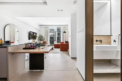 a kitchen and living room with a table and a counter at Stylish 1BR with Work Desk, Pool and Gym in Dubai
