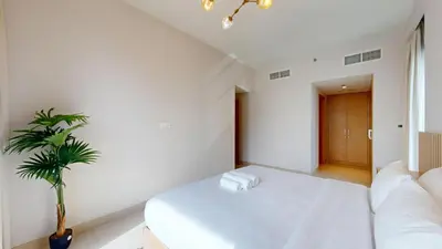 a white room with a white couch and a plant at Harbour Views - Chic Three Bed with Creek Views in Dubai