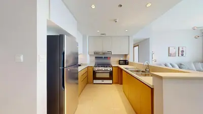 a kitchen with a stainless steel refrigerator and a sink at Harbour Views - Chic Three Bed with Creek Views in Dubai