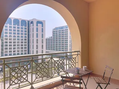 a balcony with a table and chairs and a window at Golden Mile - Serene Two Bedroom on the Palm in Dubai