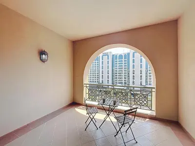 a balcony with a table and chairs and a window at Golden Mile - Serene Two Bedroom on the Palm in Dubai