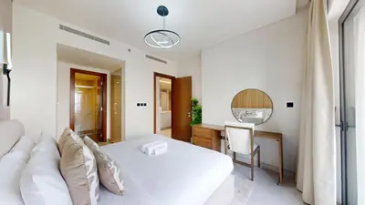 a bedroom with a white bed and a desk at The Crest A - Premium Two Bedroom High-Rise Escape in Dubai