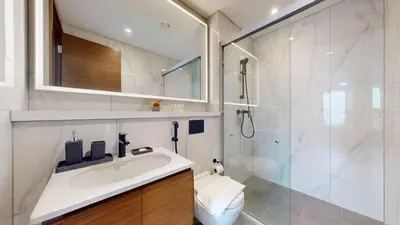 a white bathroom with a sink and a shower at The Crest A - Premium Two Bedroom High-Rise Escape in Dubai