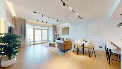 a living room with a table and a couch at Al Dabas - One Bed with Beach Access and Sea View in Dubai