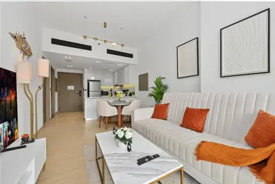 a living room with a white couch and a table at Golden Stays - Binghatti Crescent I Cozy 1BR Retreat I Pool & Gym I JVC Dubai in Dubai