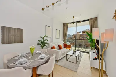 a living room with a table and a couch at Golden Stays - Binghatti Crescent I Cozy 1BR Retreat I Pool & Gym I JVC Dubai in Dubai