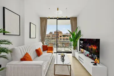 a living room with a white couch and a tv at Golden Stays - Binghatti Crescent I Cozy 1BR Retreat I Pool & Gym I JVC Dubai in Dubai