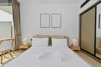a bedroom with a large white bed with two lamps at Golden Stays - Binghatti Crescent I Cozy 1BR Retreat I Pool & Gym I JVC Dubai in Dubai