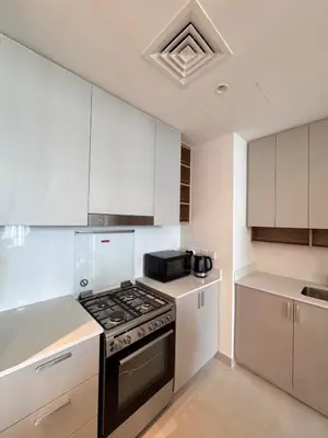 a kitchen with white cabinets and a stove top oven at Creek crescent high floor in Dubai