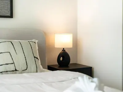 a bedroom with a bed and a lamp on a night stand at Cozy Luxury One Bedroom Sea View on Private Beach and Infinity Pool in Dubai