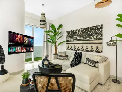 a living room with white furniture and a flat screen tv at Cozy Luxury One Bedroom Sea View on Private Beach and Infinity Pool in Dubai