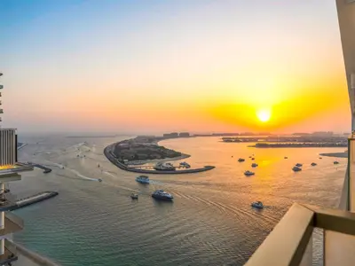 a sunset over a river with boats in the water at Cozy Luxury One Bedroom Sea View on Private Beach and Infinity Pool in Dubai