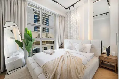 a bedroom with a white bed and a large window at Lux 3 BR Sea View Condo with Pool & Sauna In Marina in Dubai