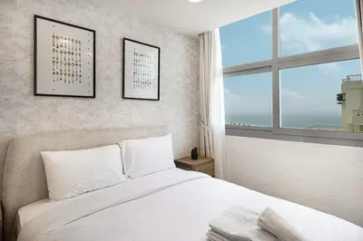 a bedroom with a white bed and a window at Lux 3 BR Sea View Condo with Pool & Sauna In Marina in Dubai