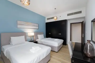 a hotel room with two beds and a desk at Jbr shams apartment in Dubai