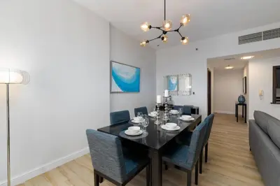 a dining room and living room with a table and chairs at Jbr shams apartment in Dubai