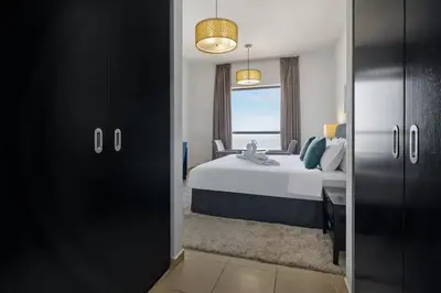 a bedroom with a large bed and a window at Jbr shams apartment in Dubai